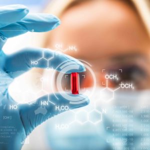 Young attractive female scientist holding a red transparent pill with futuristic scientific air interface with chemical formulas and research data in the foreground